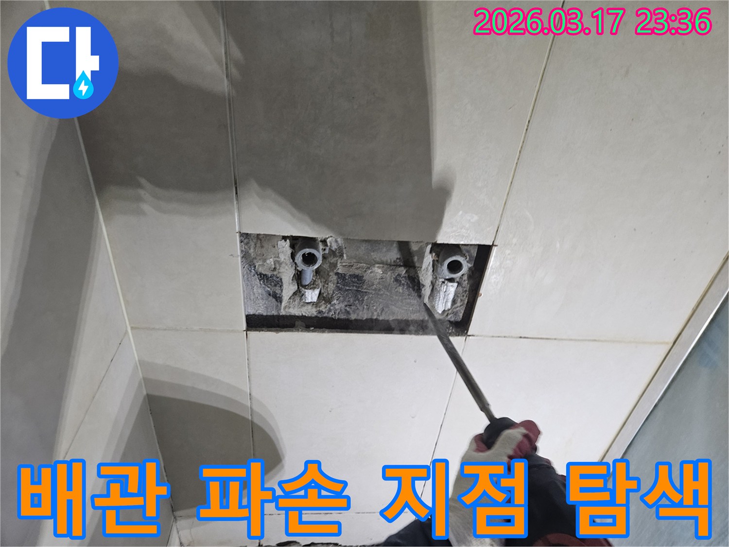 누수 지점을-찾기 위해-타일이 제거된-벽면에서-숨겨진 배관의-파손 지점을-탐색하는-모습입니다