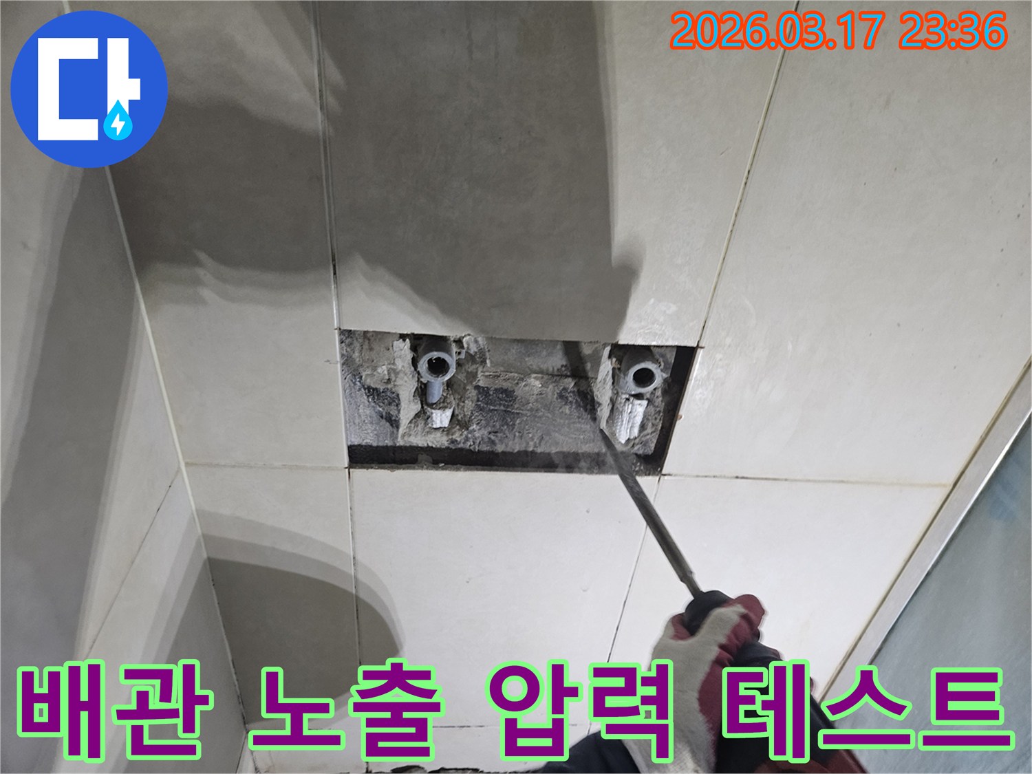 누수 해결을 위한-필수 단계로-벽면 타일 파쇄 후-배관을 노출하여-압력 테스트를-준비하는 모습입니다