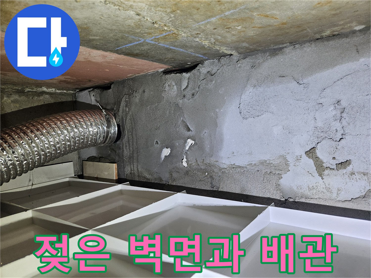 습기를 머금어 어두워진 콘크리트와 은색 관로 부위