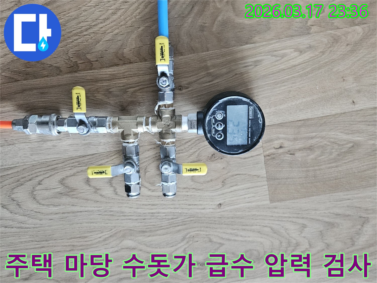 주택 마당 수돗가 급수 배관의 누수 여부를 확인하기 위해-정밀한 압력 테스트 장비를 연결하여-수치를 측정하고 있습니다.
