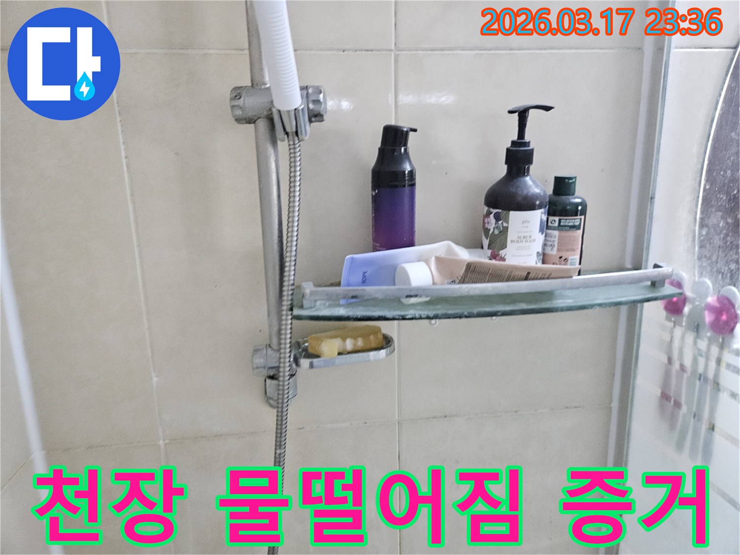 화장실 샤워기 옆-유리 선반에 맺힌 물방울은-천장 누수의 간접적인 증거를 보여주는 이미지입니다