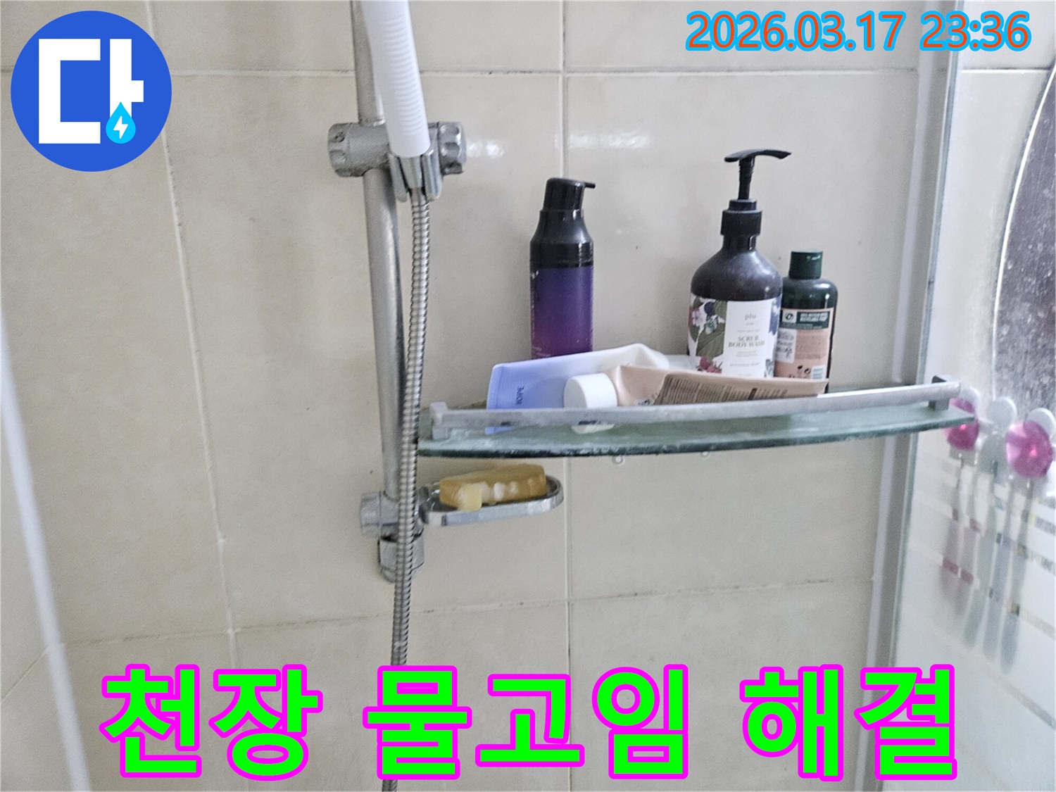 화장실 샤워기 옆-유리 선반에 맺힌 물방울은-천장 물고임의 간접적인 증거를 보여주는 이미지입니다