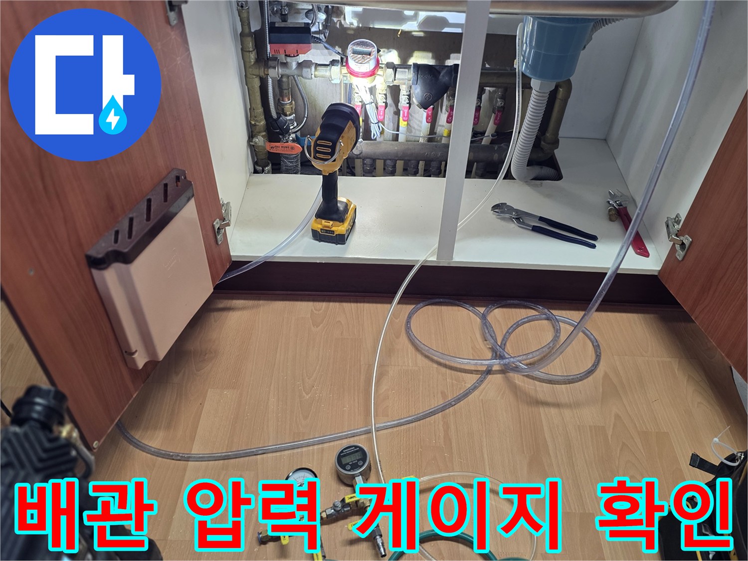 싱크대 아래 분배기에 연결되어 작동 중인 공압 게이지