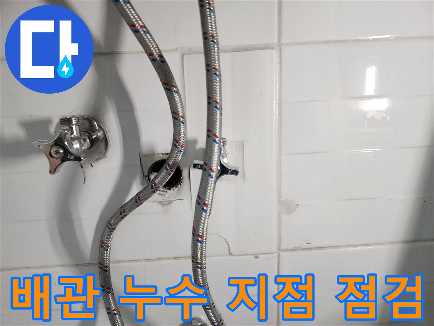 벽면 타일 사이로 노출된-수전 및 급수 호스 부위