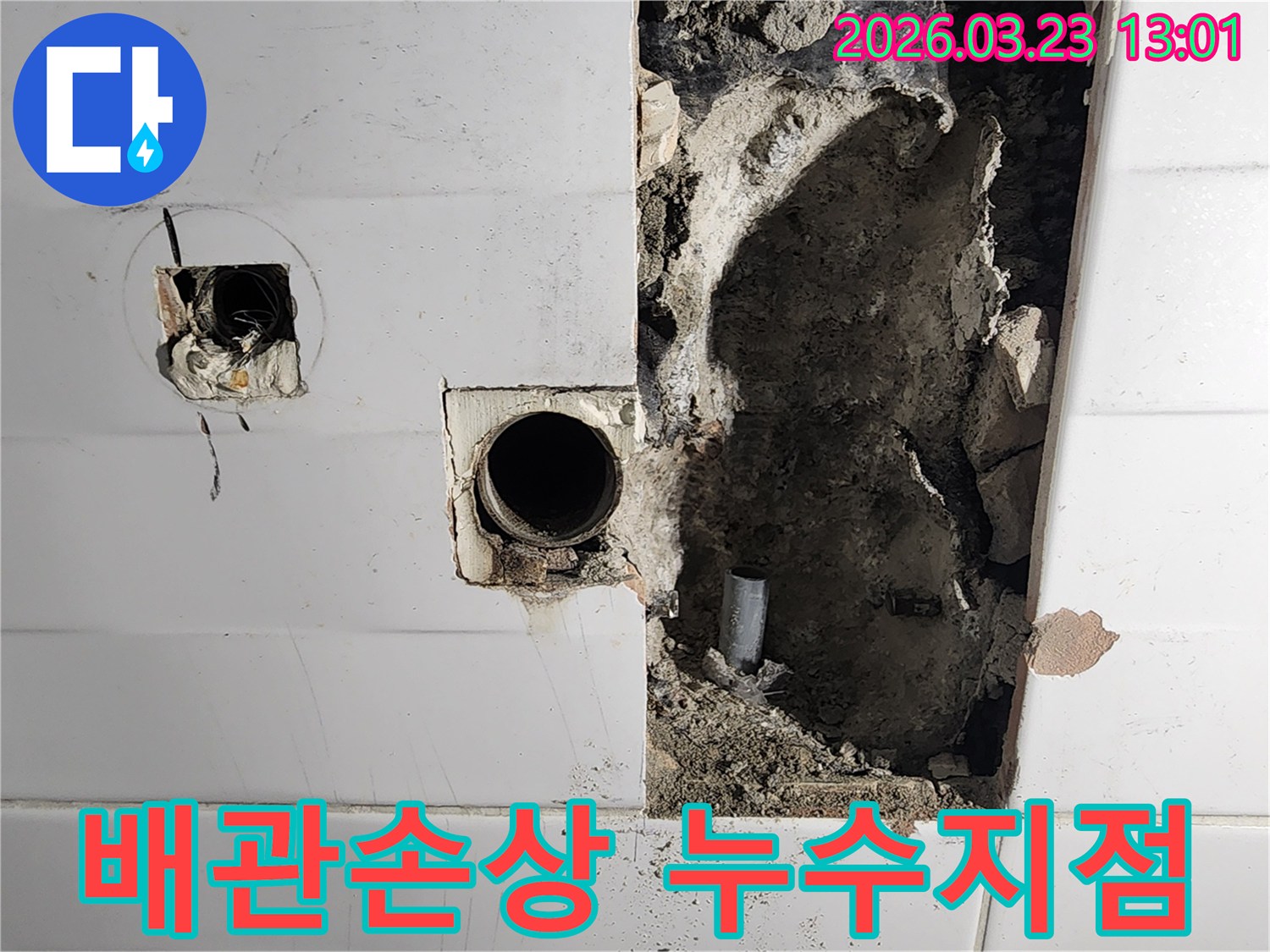 벽체 내부의 손상된 배관과-주변의 젖은 흙이 보이는-누수 공사 현장의 초기 단계 모습