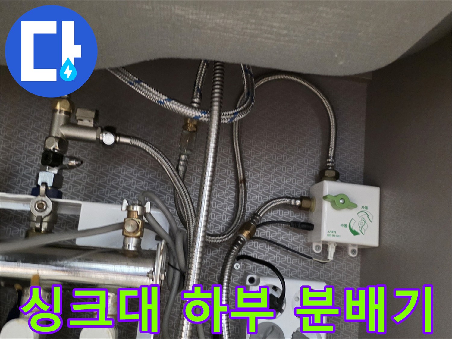 싱크대 아래 금속 분배기와 연결된 은색 배관들의 모습