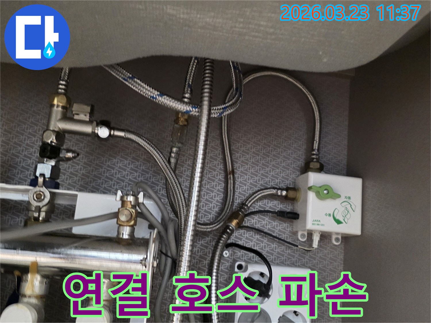 싱크대 하부장 내부의 파손된 수도-연결-호스와 정수기-밸브-배관-전기 콘센트가-보이는 곳에서-누수 흔적을-찾아내고 있습니다.