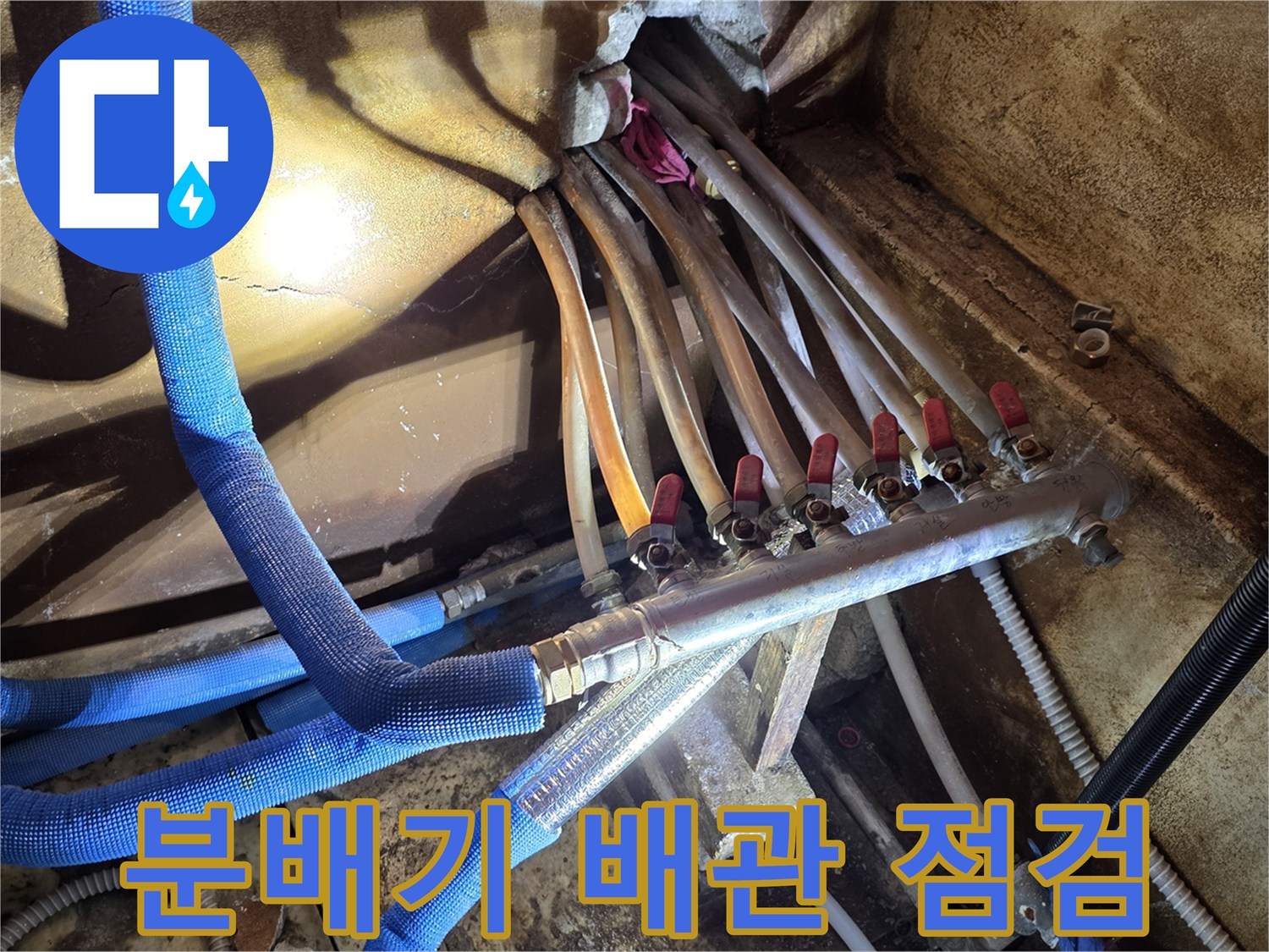 파란색 보온재로 감싸진 난방 분배기 연결 부위 모습