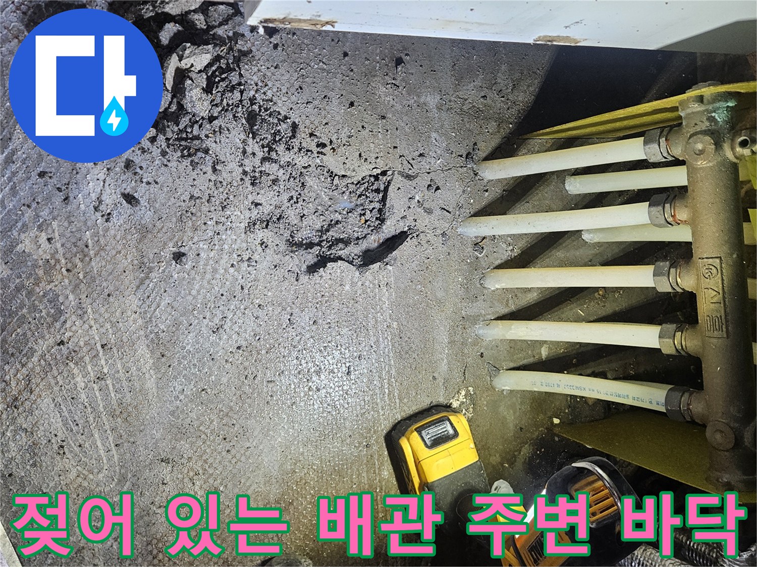 싱크대 하부 분배기 배관 주위의 젖은 바닥과 파쇄된 잔해물