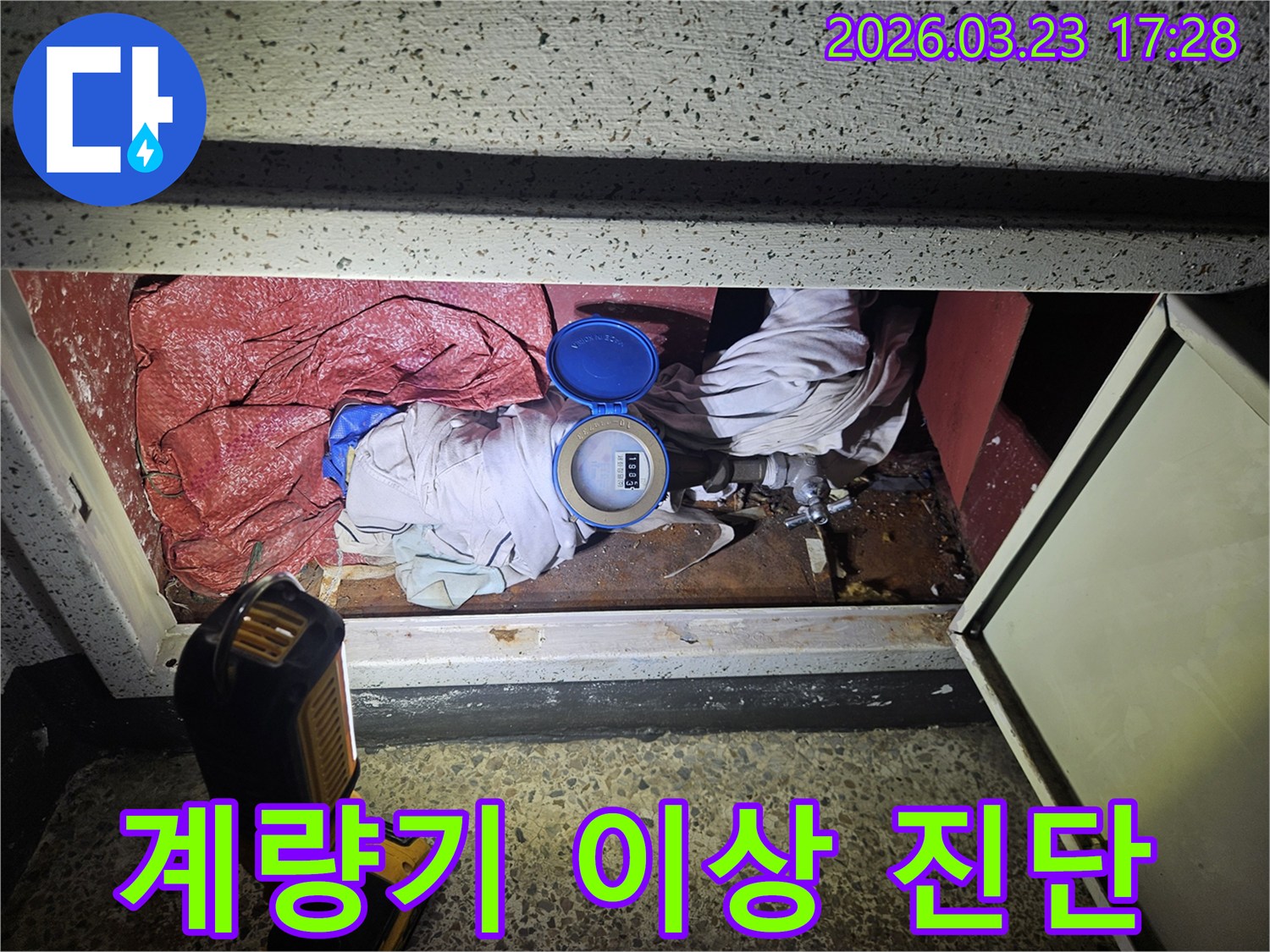 어두운 공간에서 물 계량기 주변을 정밀하게 확인하는 누수 탐지 현장