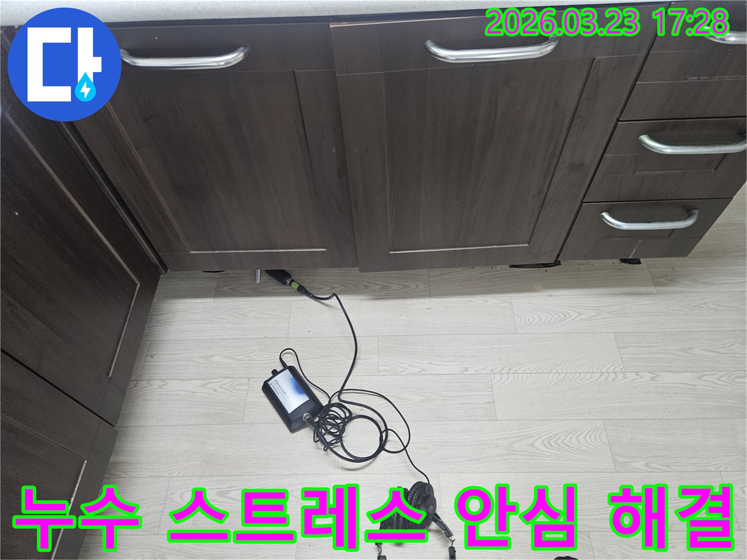 용인 기흥구 주방 싱크대 하부에서-누수로 인한 고객의 스트레스를 해결하기 위해-청음식 탐지 장비로-정밀하게 검사하는 엔지니어의 모습