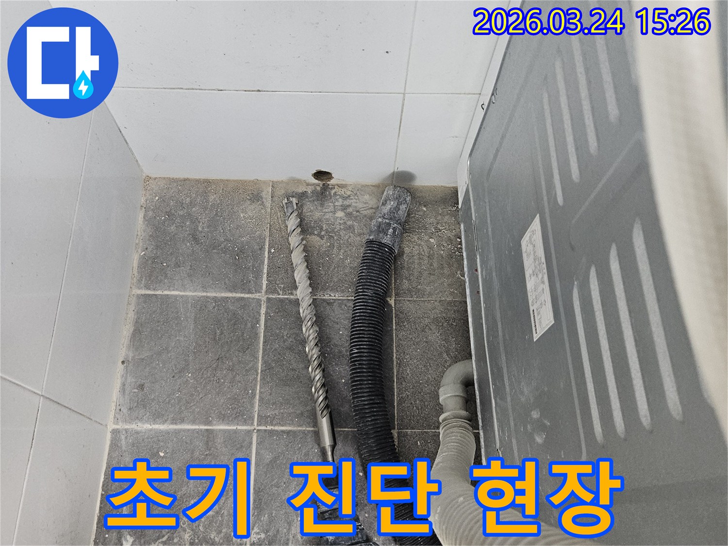 누수 엔지니어가-누수 공사 현장에서-초기 진단을 위해-타일 벽면에 드릴링 작업을 하고 있습니다-정확한 원인 파악을 위한 중요한 단계입니다