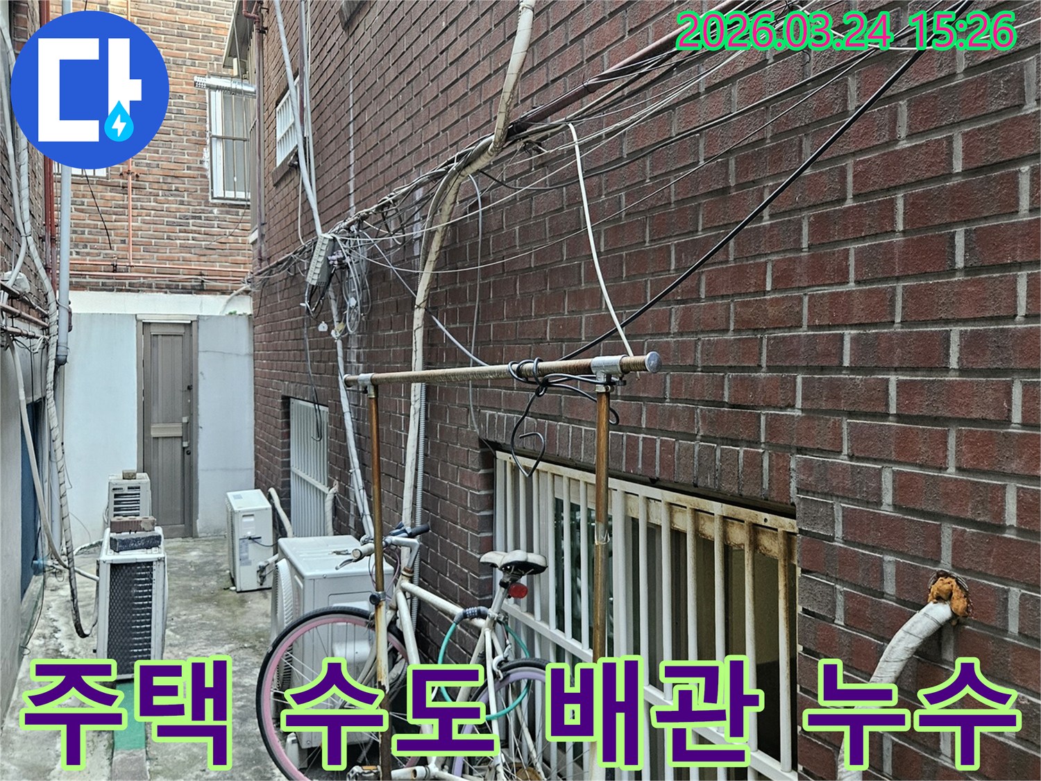 오래된 주택 외벽에-복잡하게 얽힌 수도 배관과-전선-누수탐지 전 현장 확인