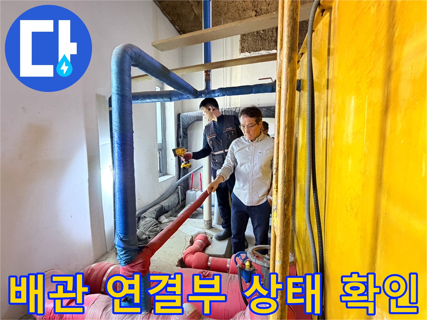 엔지니어가 분홍색 보온재로 감싸진 굵은 배관의 연결 부위를 집중적으로 점검하고 있습니다.