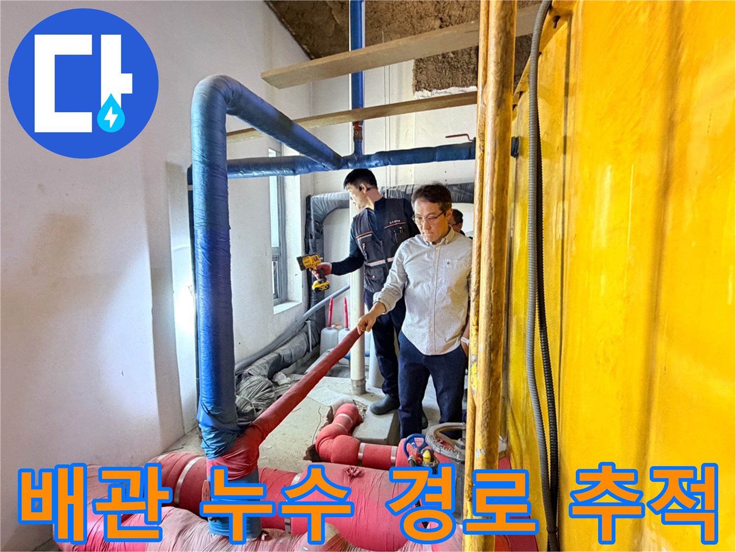 파란색 배관과 분홍색 배관이 만나는 지점을 엔지니어가 면밀히 조사하고 있습니다.