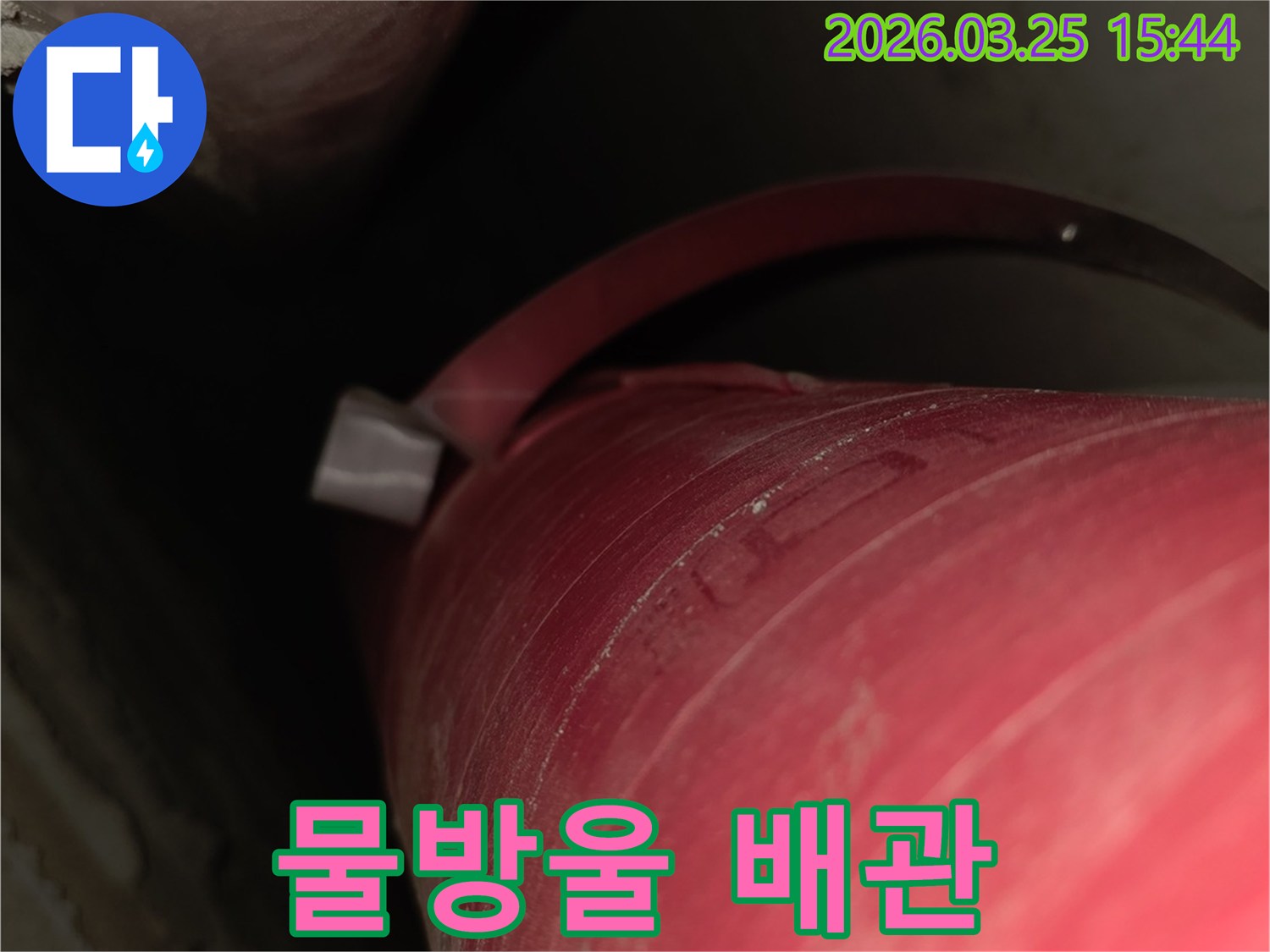 어두운 곳에서-붉은 배관의-물샘을-선명하게 보여주는-이미지입니다.