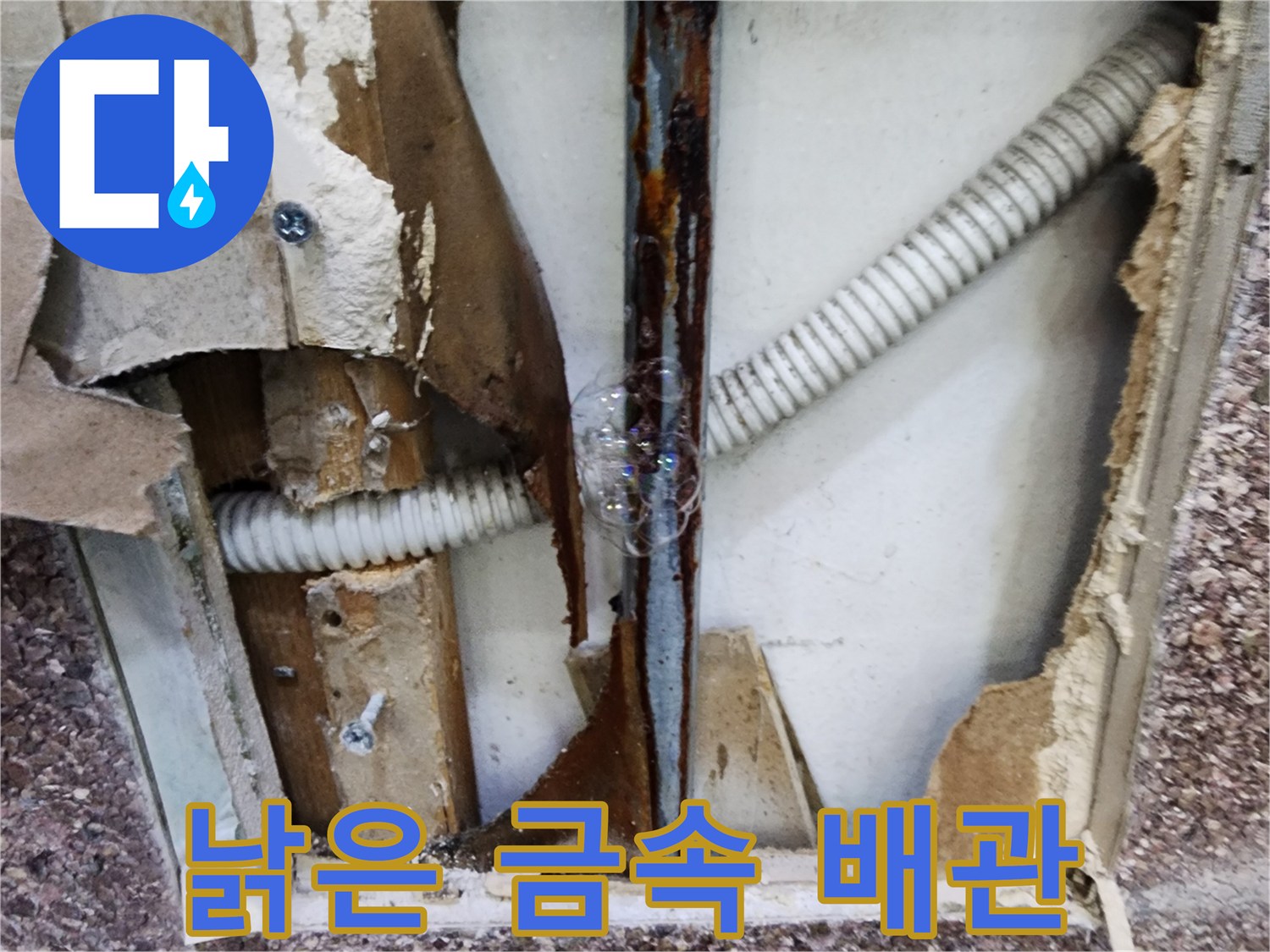부식된 금속 관과 주름진 배수관이 노출된 벽면 내부 상황