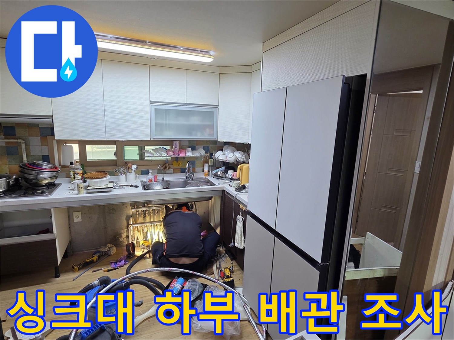 싱크대 아래 좁은 공간에서 진행되는 정밀 누수 진단 모습입니다.