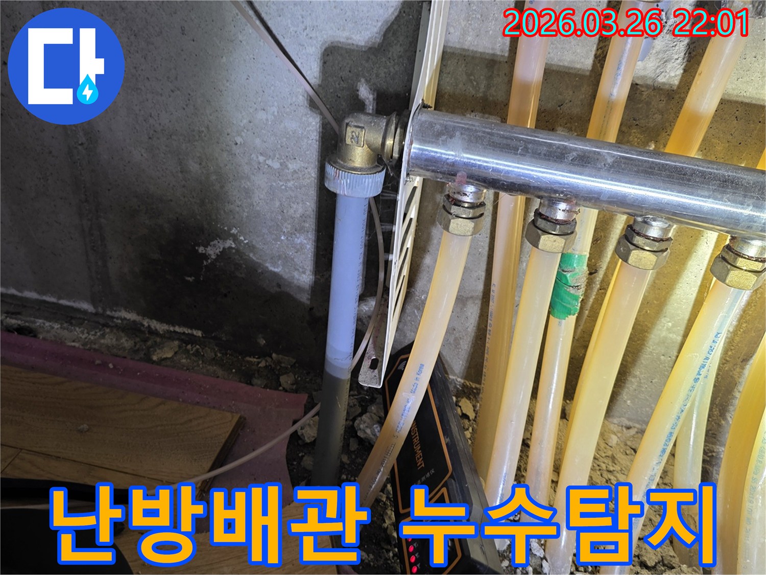 이 이미지는-온수 배관 누수-탐지 현장에서-젖은 벽면과-배관-그리고-탐지 장비를-보여줍니다.