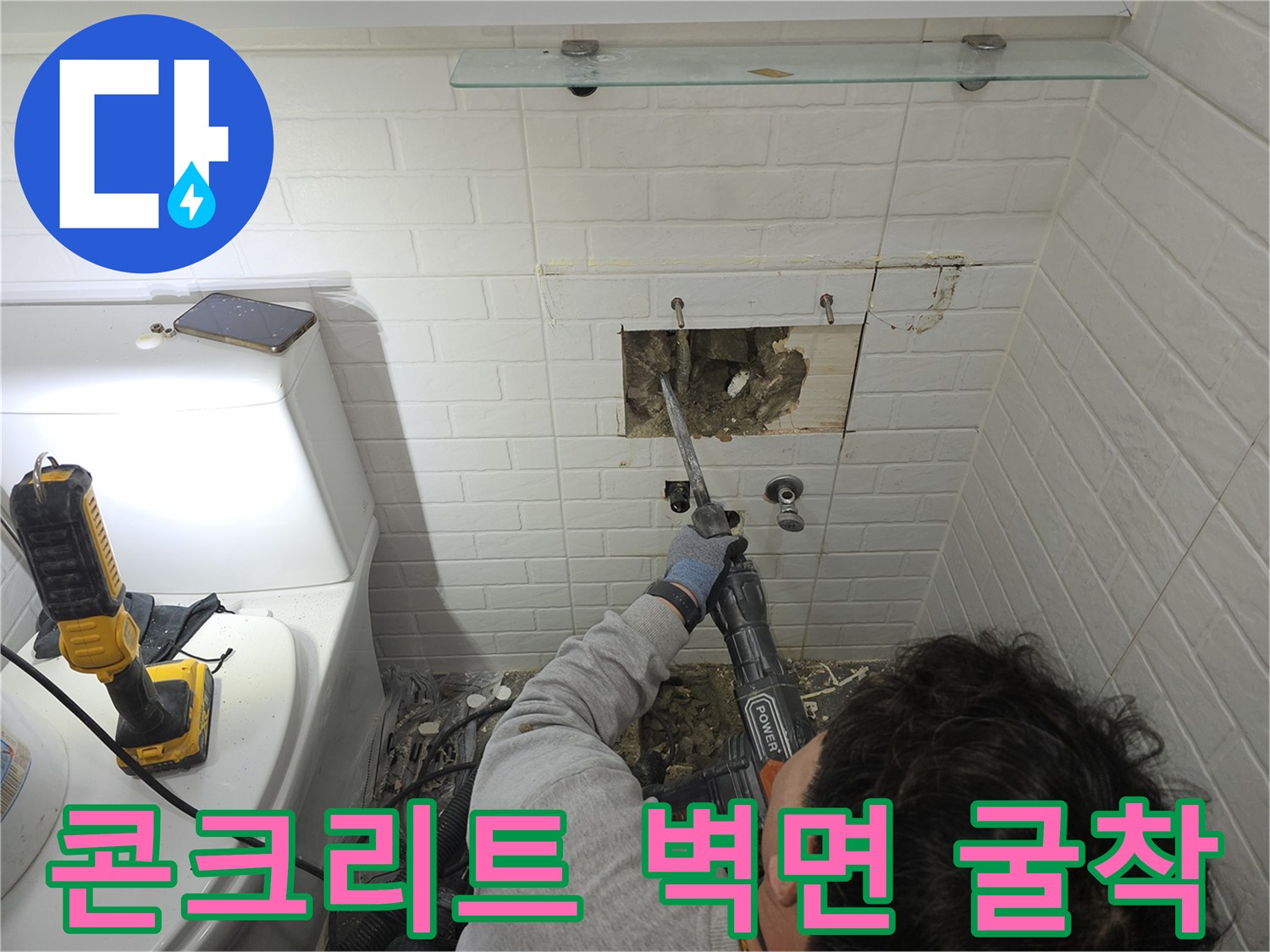 벽 내부 배관의 결함을 찾아내기 위해 타일과 콘크리트를 제거하는 공사 현장입니다.