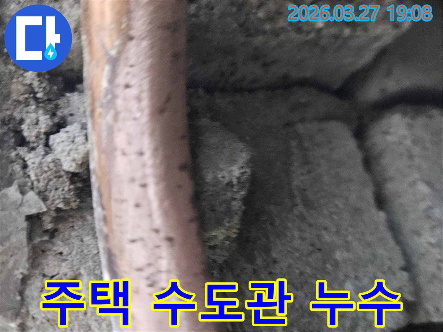 콘크리트-구조물-사이에-놓인-오래된-주택-수도-배관의-부식-및-누수-현상을-보여주는-사진입니다