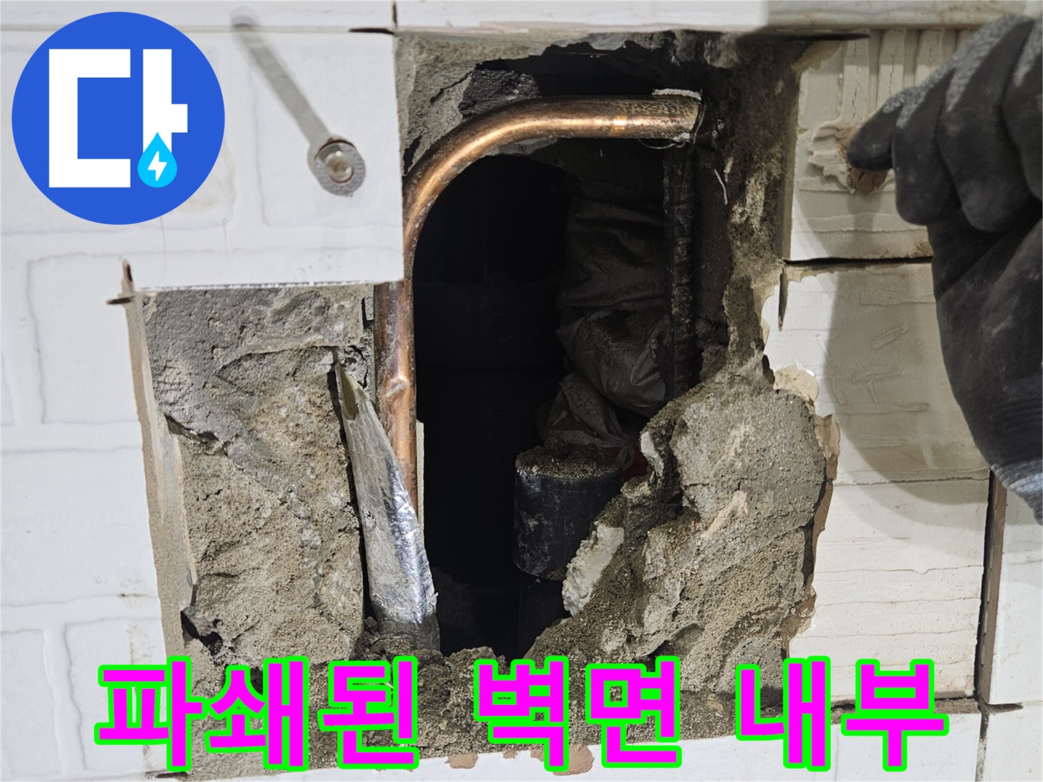 콘크리트 층 사이로 노출된 누수 발생 구리 배관