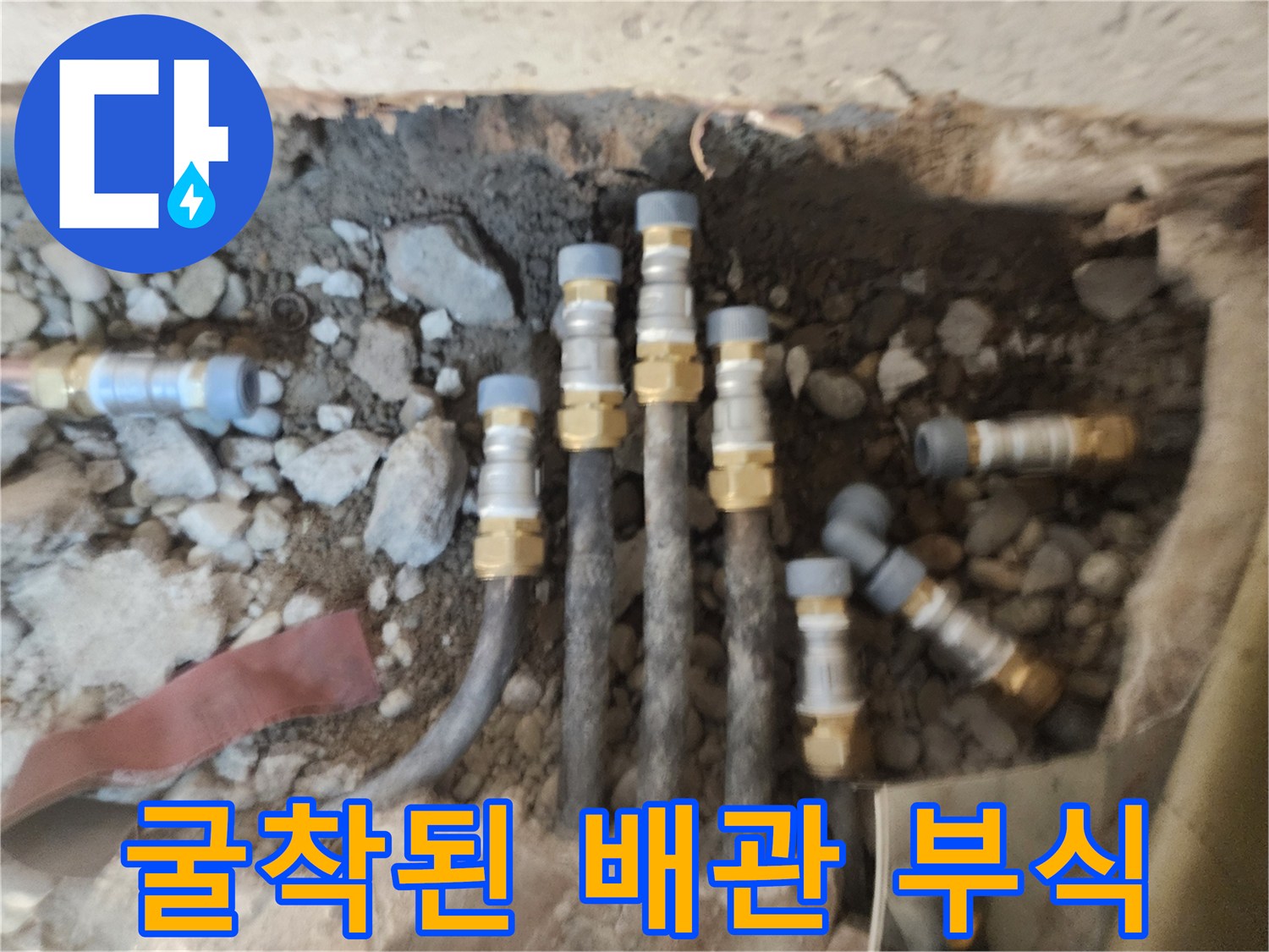 자갈과 흙 사이로 보이는 부식된 금속 연결 부위