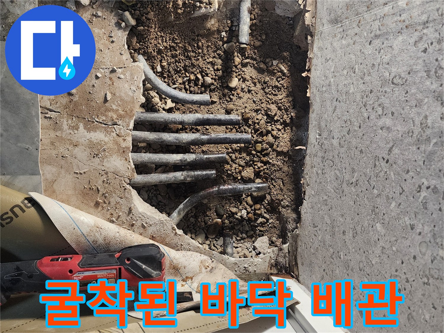 흙과 자갈 사이로 드러난 노후된 수도 배관