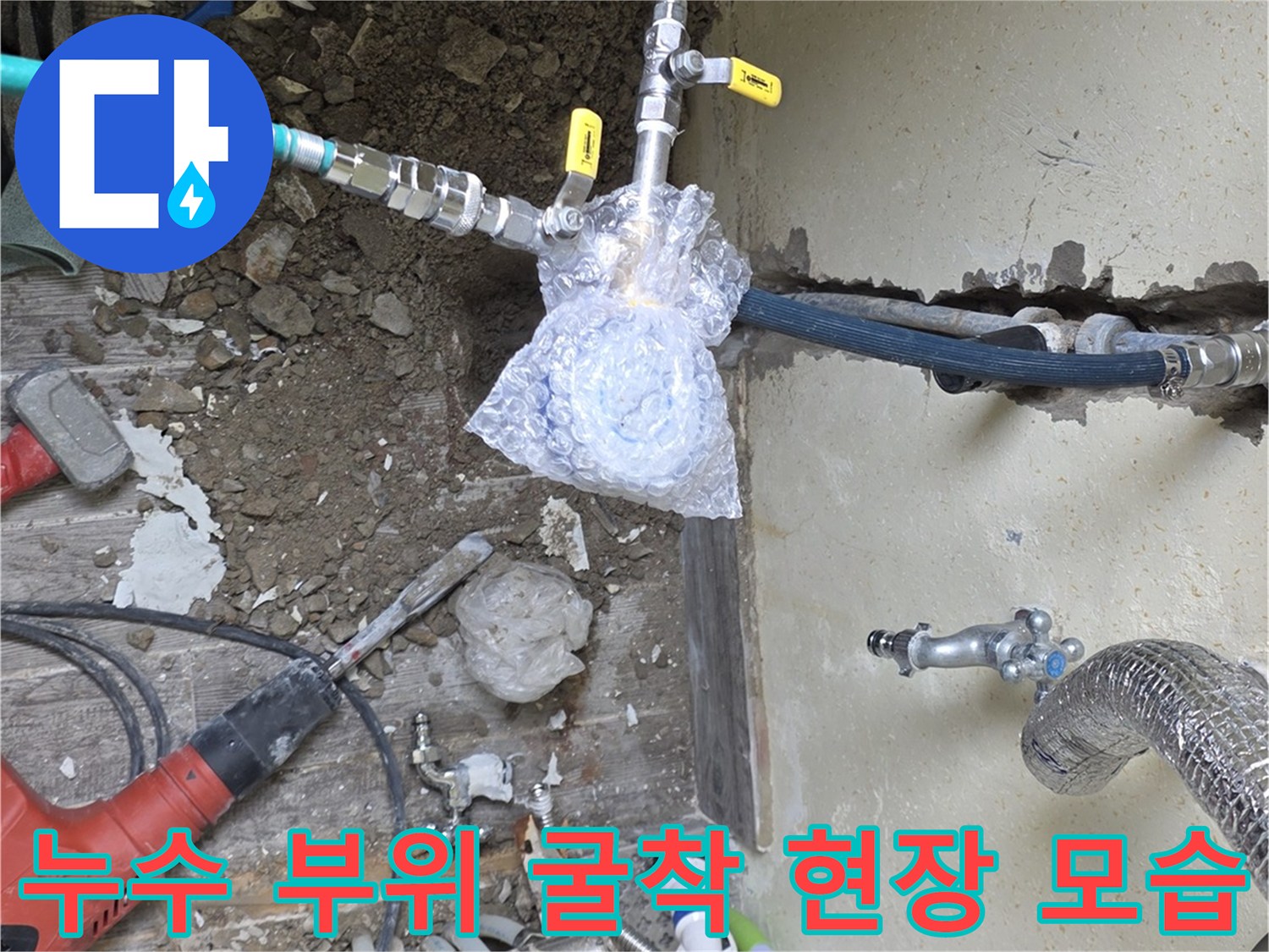 배관 수리를 위해 흙과 잔해를 제거한 보일러실 벽면 하단부