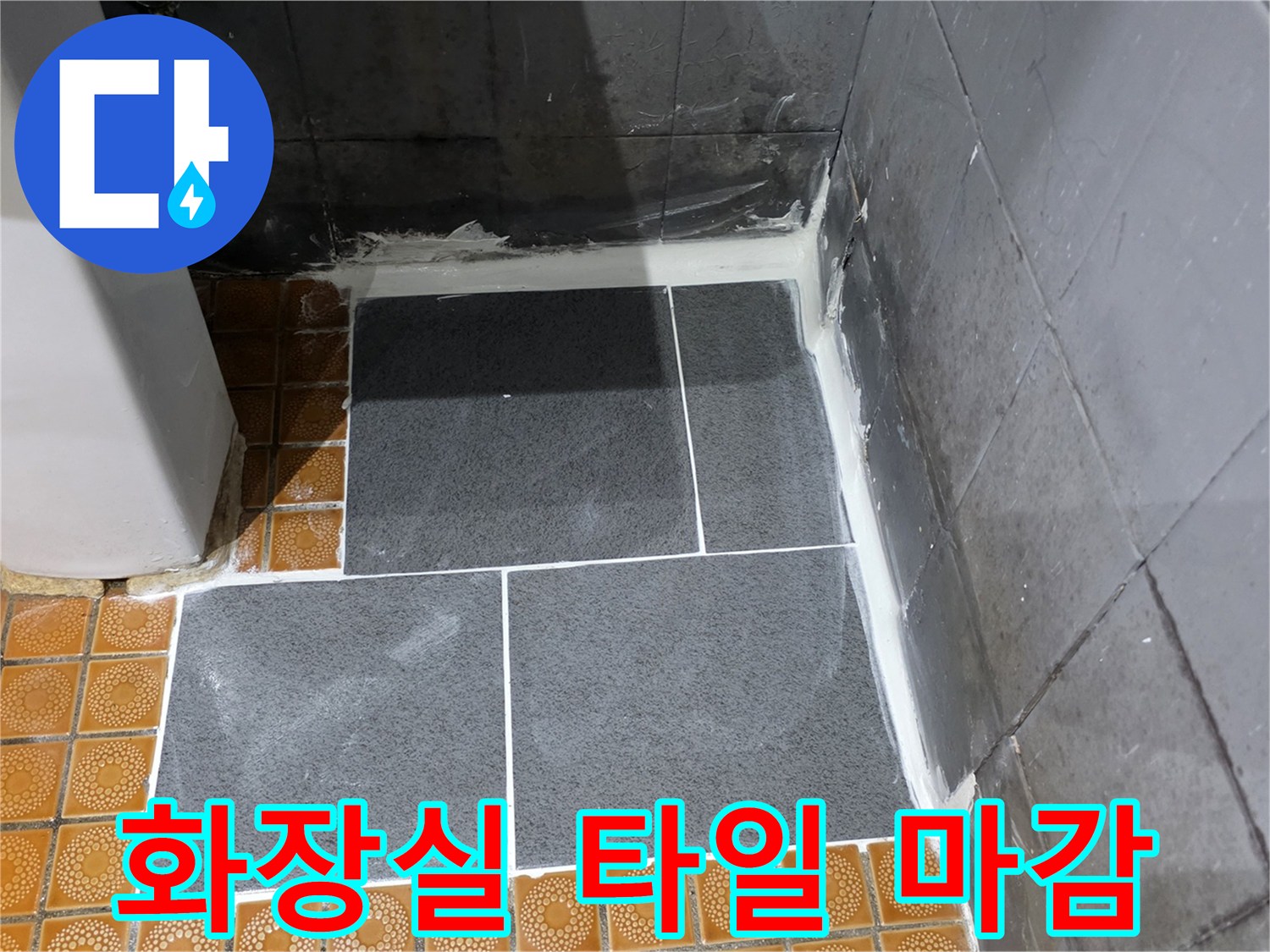 파주 문산 화장실 현장의 짙은 회색 타일과 황토색 타일이 만나는 마감 부위