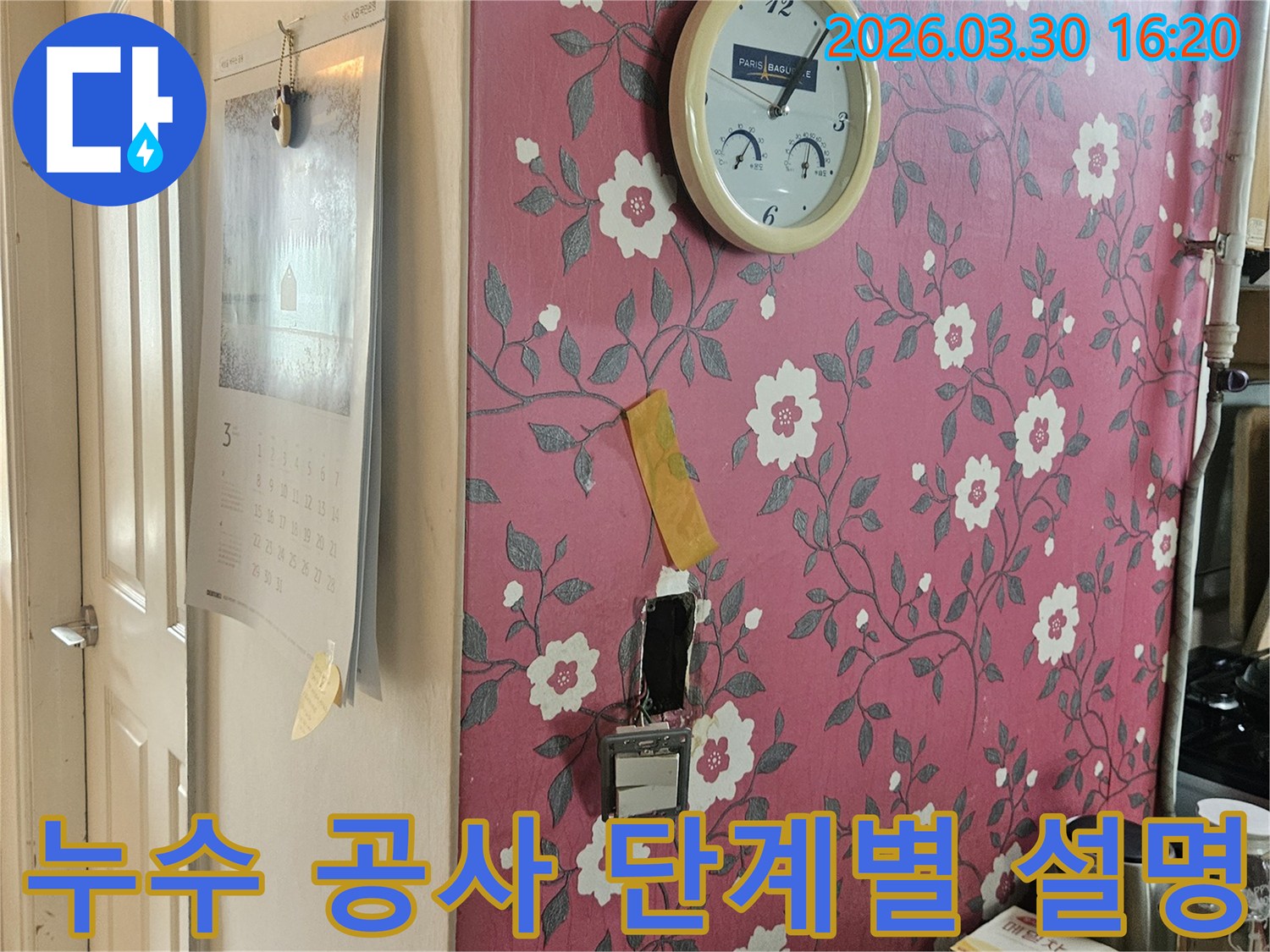 분홍색 꽃무늬 벽지에-시계가-걸려있고-누수-탐지를-위해-개방된-벽면을-보며-누수-공사-진행-단계를-설명하는-사진입니다