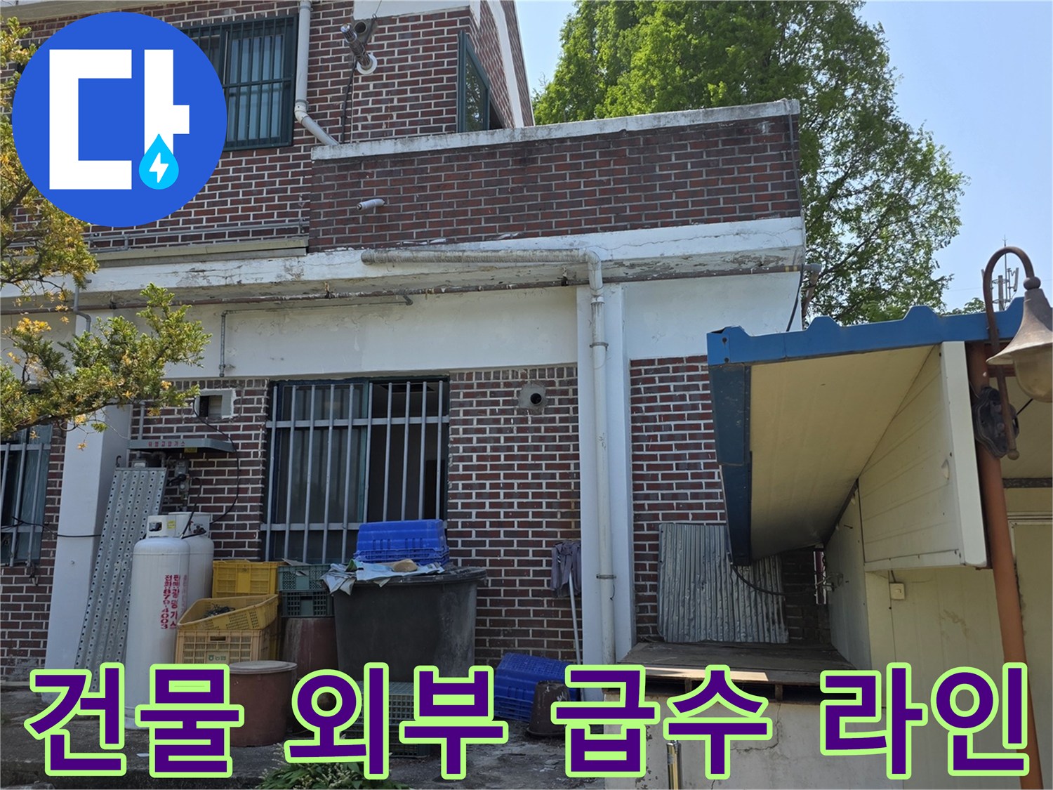 붉은 벽돌 구조물의 외벽과 그 주변에 설치된 배관 시설입니다.