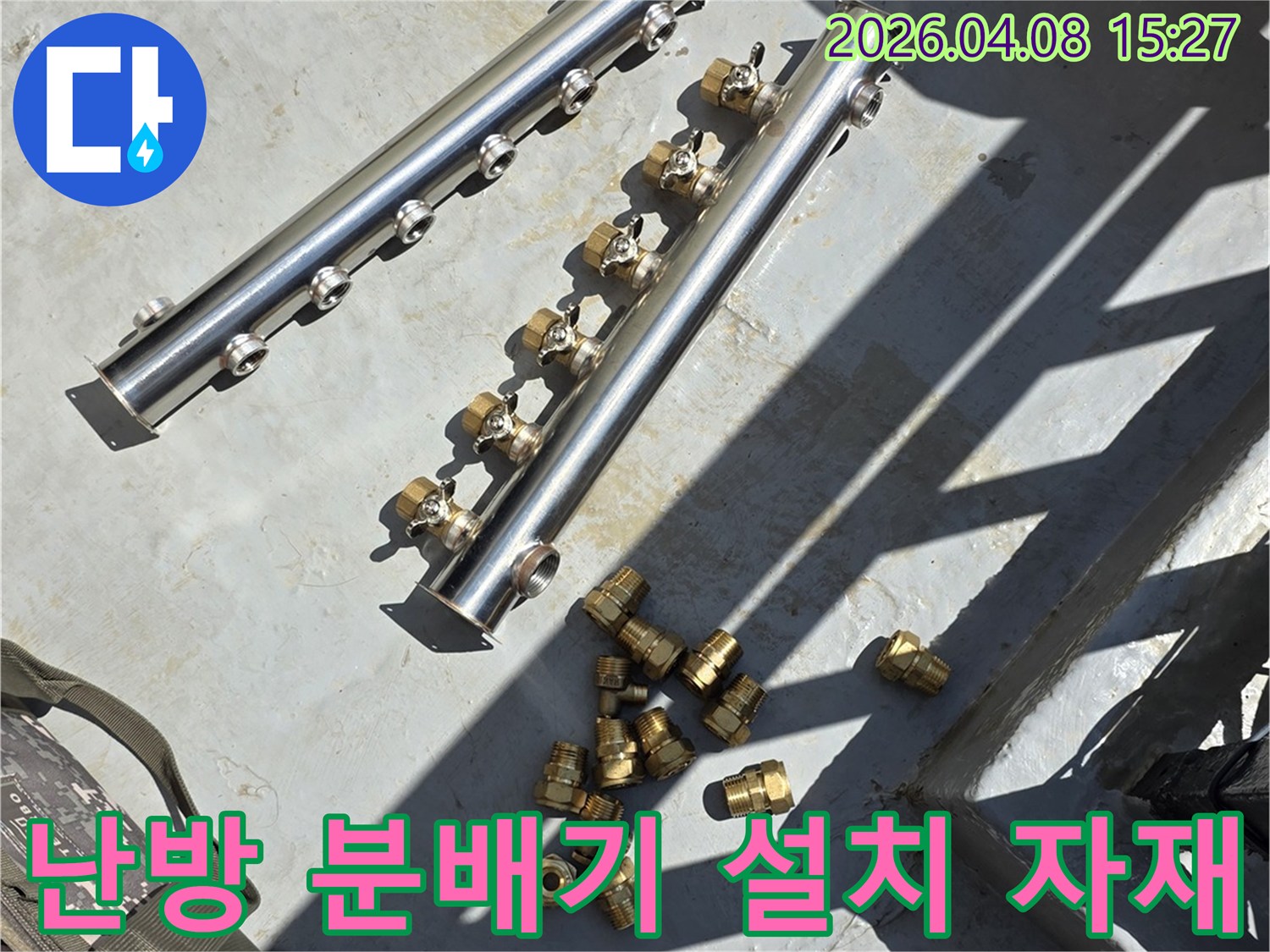 난방 배관 누수 수리를 위해-새롭게 설치될 스테인리스 분배기와-다양한 황동 연결 부속들이 준비된 모습