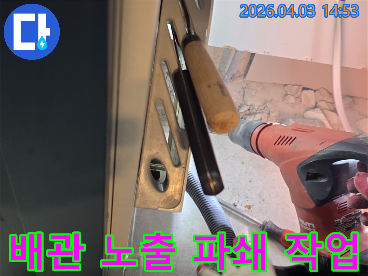 누수된 배관을 노출시키기 위해 전문 장비로 바닥 콘크리트를 파쇄하는 현장입니다-숙련된 기술자의 정밀한 작업이 이루어지고 있습니다