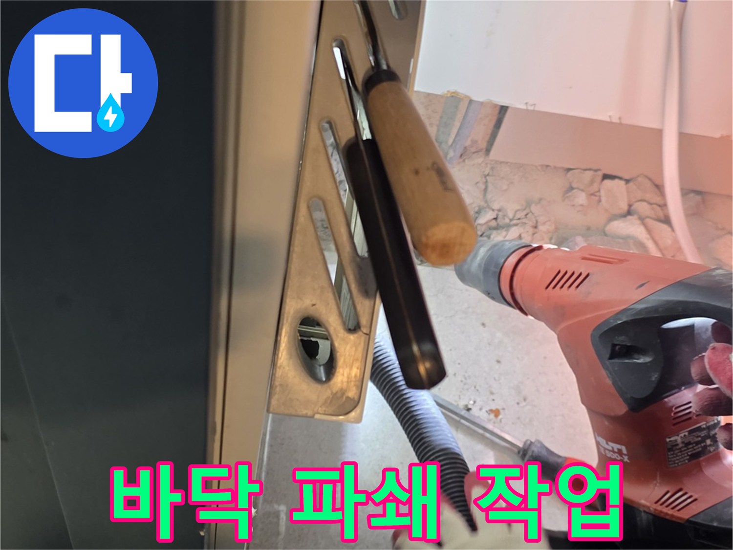 드릴을 사용하여 배관 주변의 콘크리트를 제거하는 모습입니다.