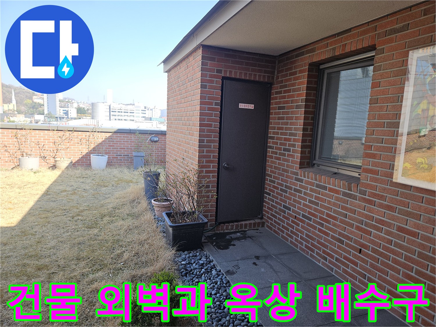 붉은색 벽돌 외벽과 자갈이 채워진 옥상 배수 구역 모습
