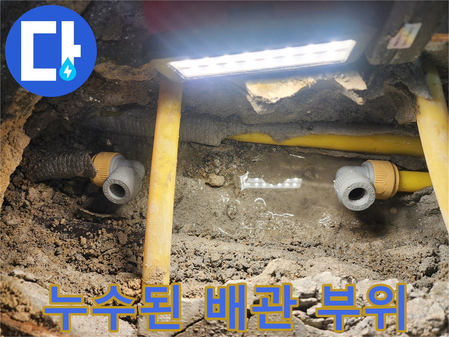 배관 파손 현장-물이 고여 있는 굴착 부위와 노란색 보호관