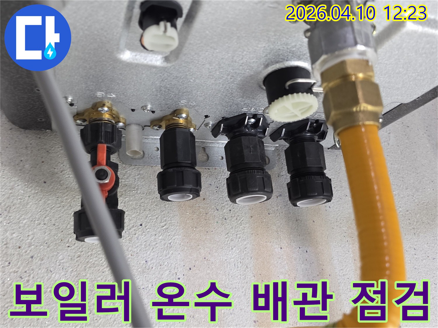 보일러 하단부에 위치한 온수 및 급수 배관의 연결 상태를 면밀히 확인하고 있는 모습입니다-누수 발생 가능성을 사전에 차단하기 위한 필수적인 과정입니다.