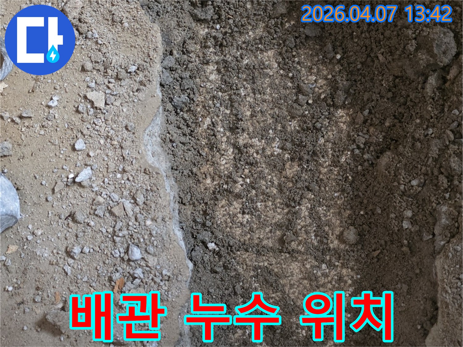 누수-현장에서-땅을-파내어-젖은-흙과-배관이-드러난-모습을-담은-사진