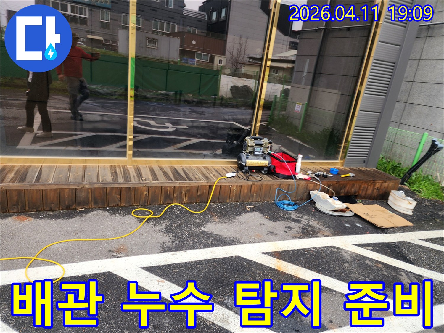 건물 외부에서 배관 누수를 탐지하기 위한-장비들이 세팅된 장면입니다