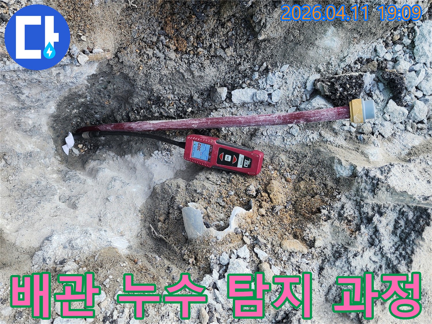누수 지점을 찾기 위해-땅을 파헤치고-배관에 연결된-탐지 장비의 근접 사진입니다.
