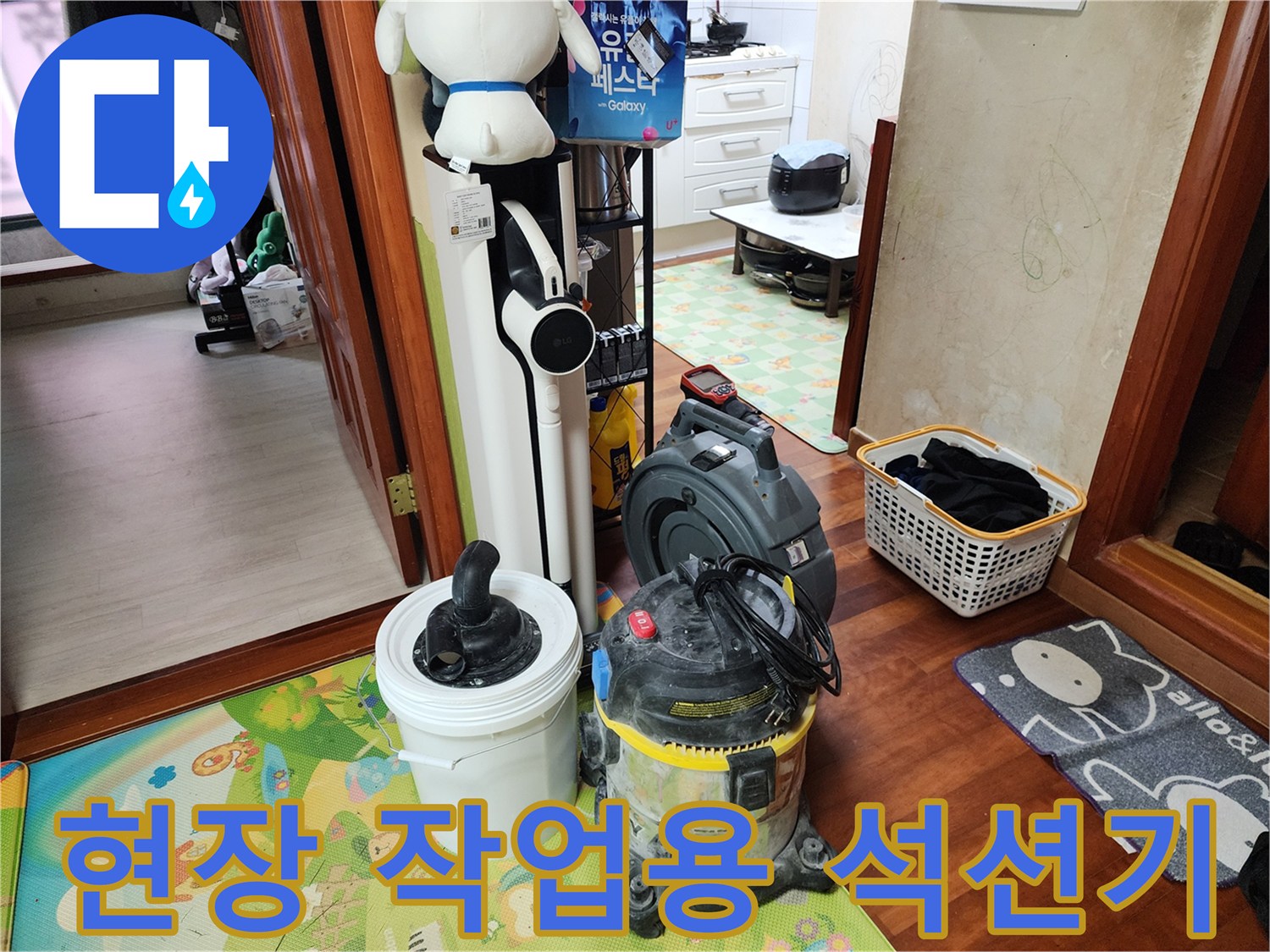 세탁실 바닥에 놓인 산업용 석션기와 오물 수거통
