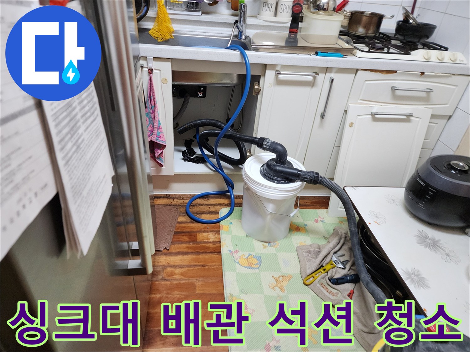 싱크대 밑 배수 호스에 연결된 전문 석션 장비와 수거 용기