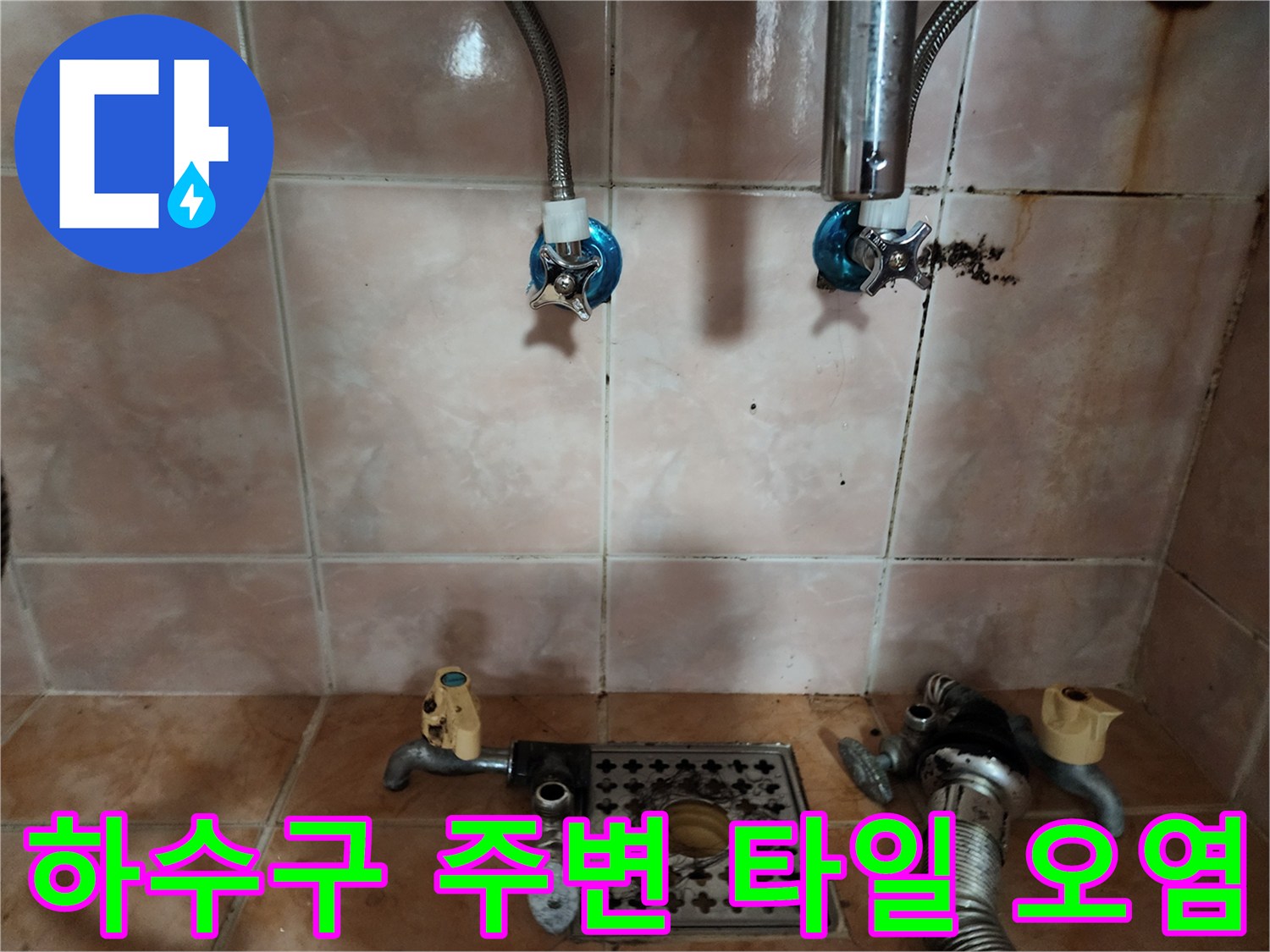오염된 타일과 배수구 주변의 노출된 금속 배관