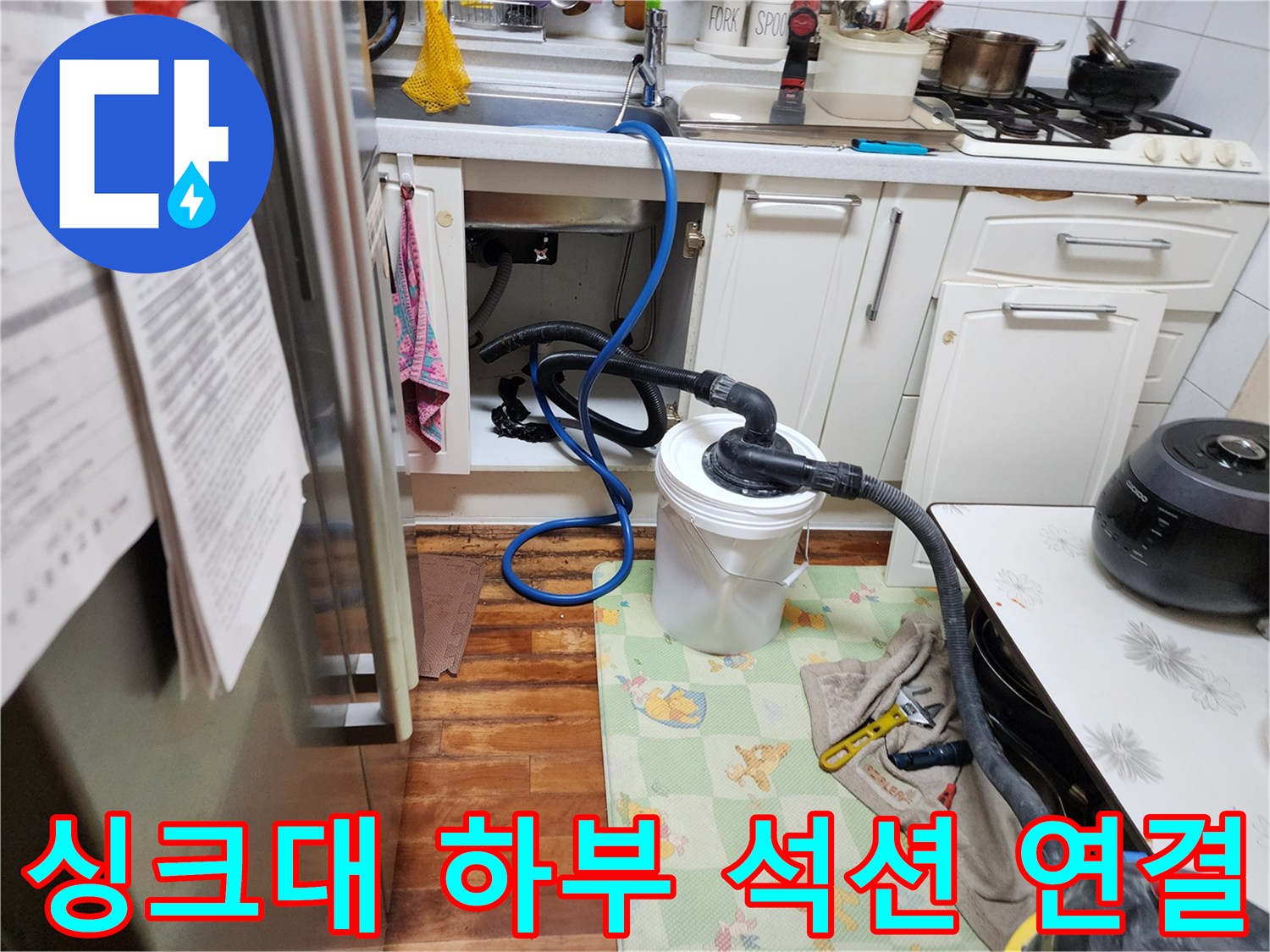 주방 싱크대 밑 배관에 연결된 석션 호스와 수거 용기