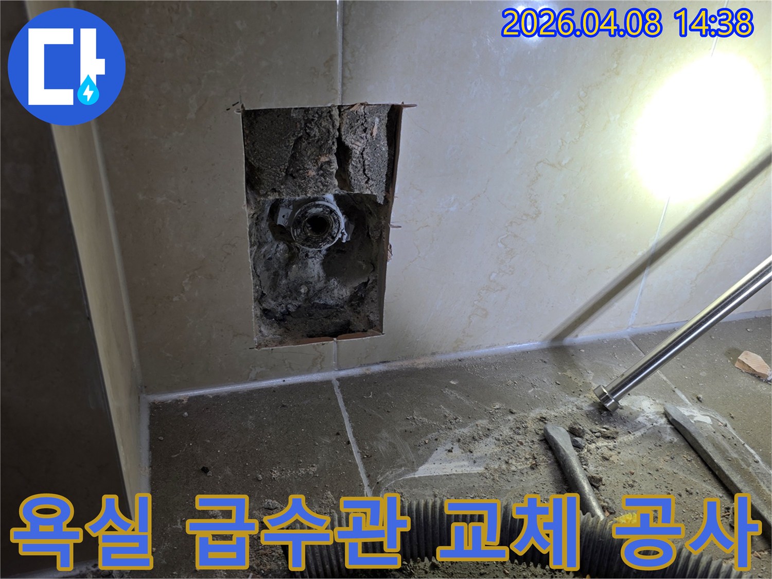 김포 한강센트럴자이 욕실에서 손상된 급수관을 교체하기 위해 벽면을 개방한 공사 현장입니다-노후된 배관의 교체 작업이 진행 중입니다