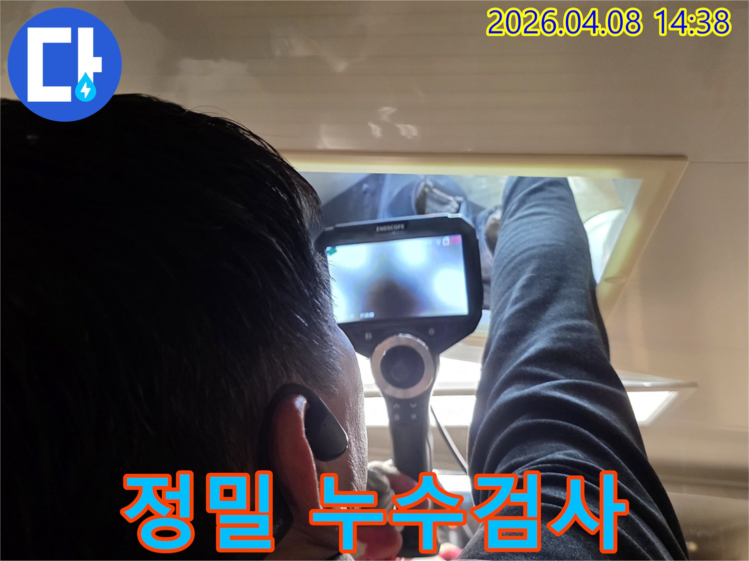 누수 탐지 전문가가 내시경 카메라를 사용하여 숨겨진 공간의 누수 흔적을 면밀히 검토하는 장면