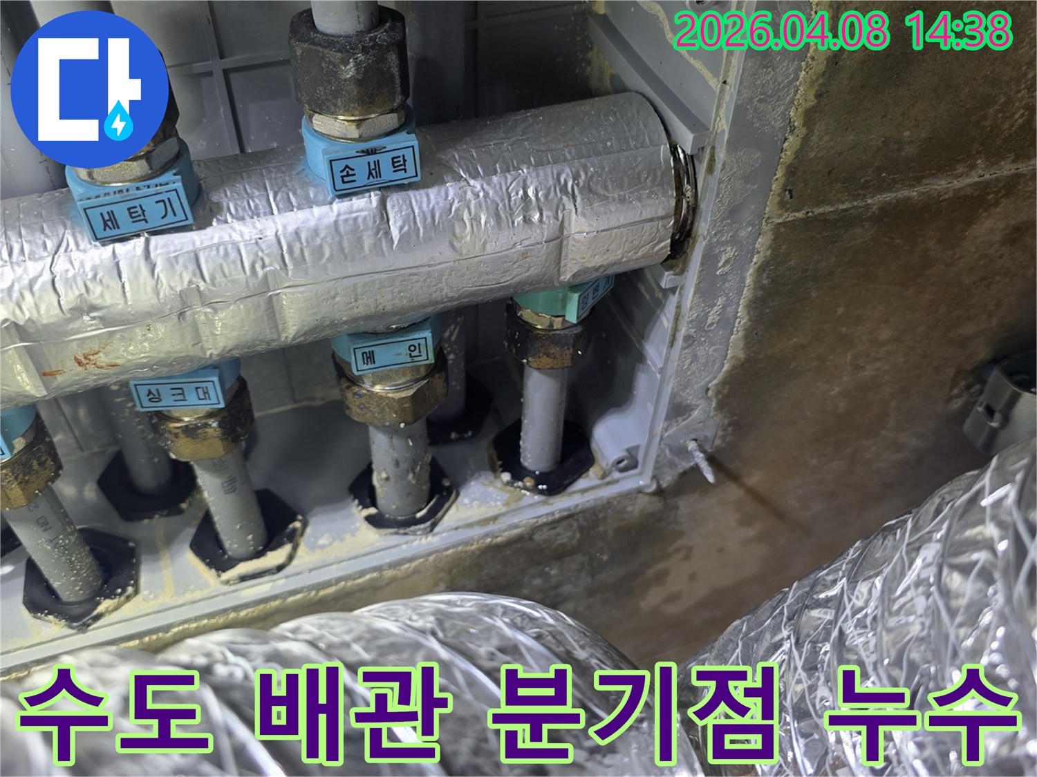 수도 배관의 분기점에서-발생한 부식과 누수 흔적을-보여주는 현장 사진입니다