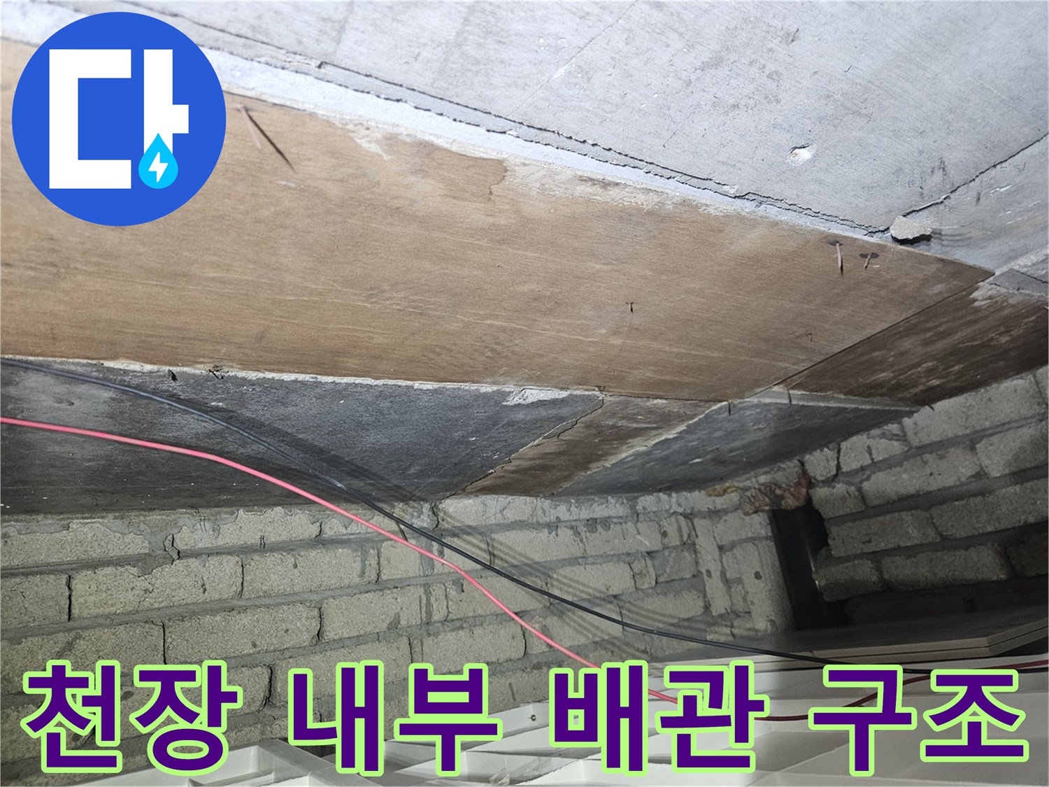건물 천장 내부의 나무 판재와 노출된 전선 상태를 보여주는 사진