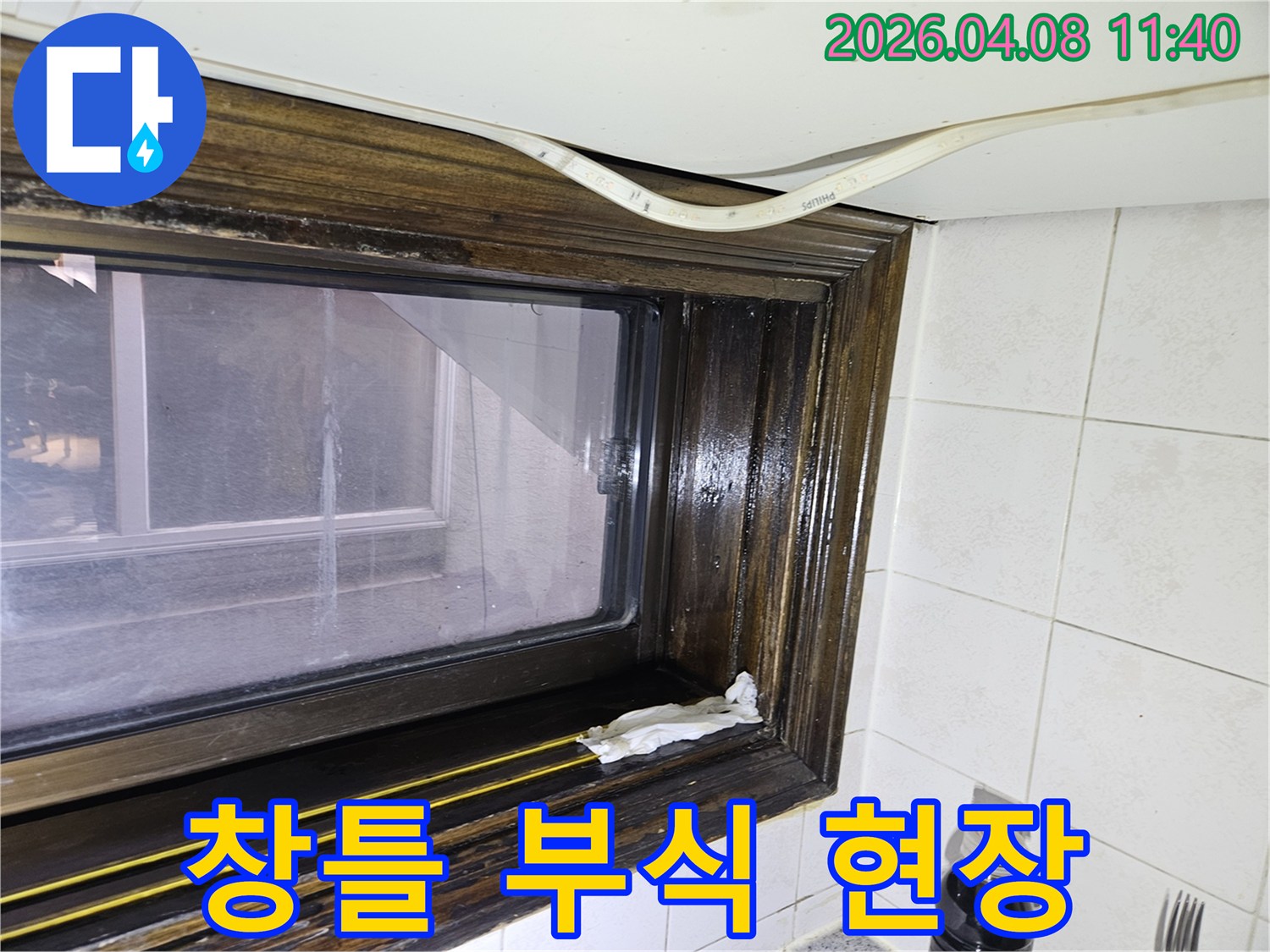 오래된 창틀에서 발견된 물샘-흔적을 보여주는 이미지로-누수 전문가가 현장을 점검하고 있습니다.